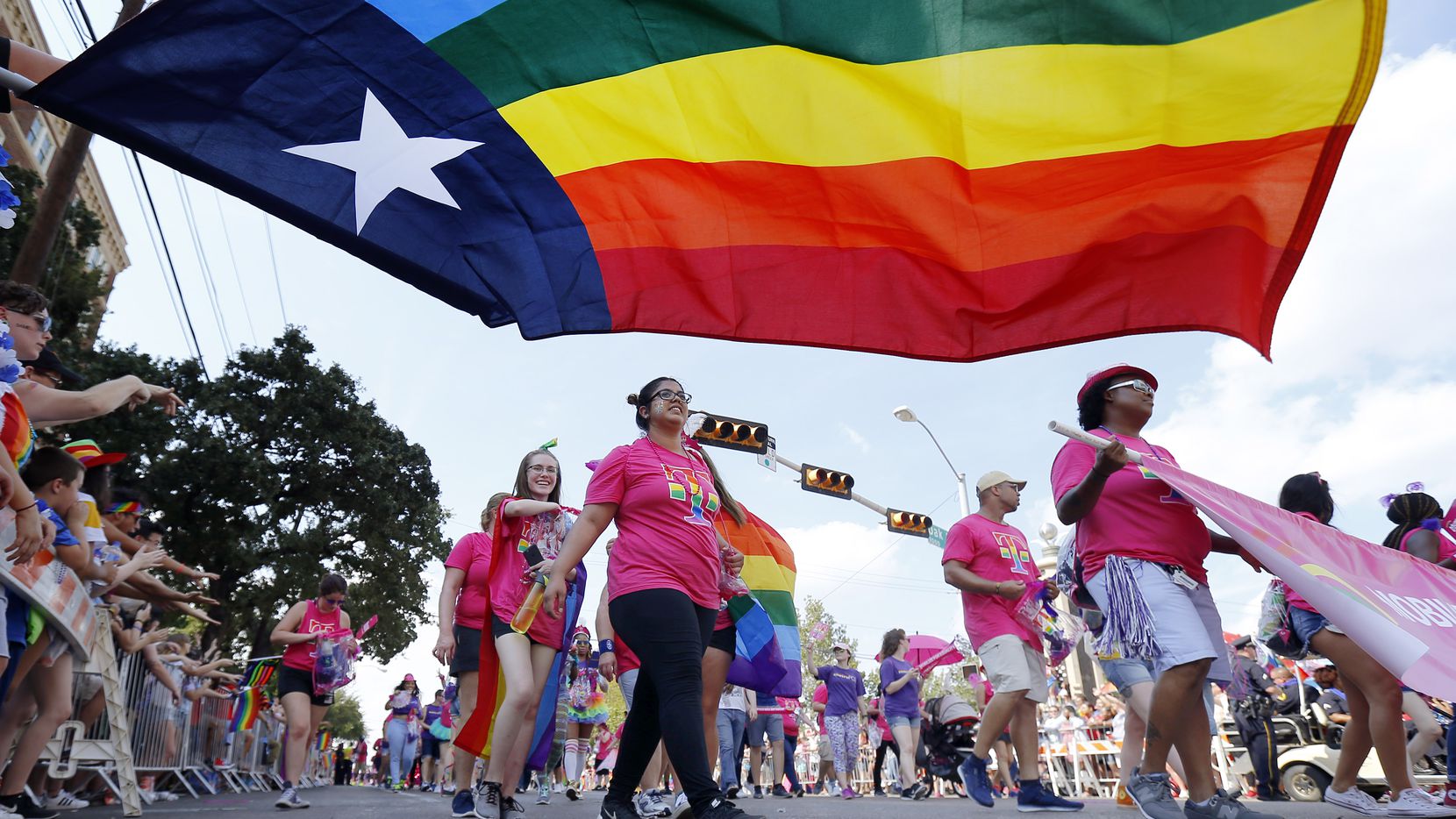 People marching with the Mobilize for Equality group pass by the Texas rainbow flag during the Texas Freedom Parade, Sunday, September 17, 2017. On Monday, June 15, 2020, the U.S. Supreme Court issued a landmark ruling extending employment protections to LGBT workers. (Tom Fox/Staff Photographer)
