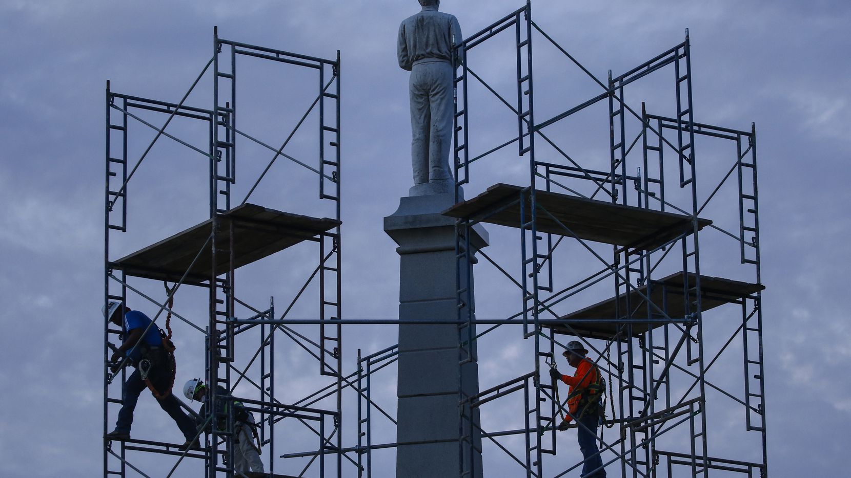 In this June 24, 2020, file photo, construction workers remove the final soldier statue, which sat atop The Confederate War Memorial in downtown Dallas. The Confederate battle flag is losing its place of official prominence in the South 155 years after the end of the Civil War and some Southern localities have removed memorials and statues dedicated to the Confederate cause. (Ryan Michalesko)