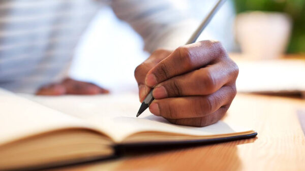 man writing in book