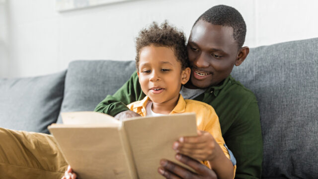 African American father and son reading