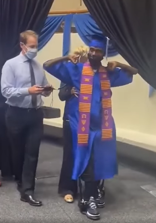 Corey Borner walks across the stage with high tech assistance to accept his college diploma at UNT