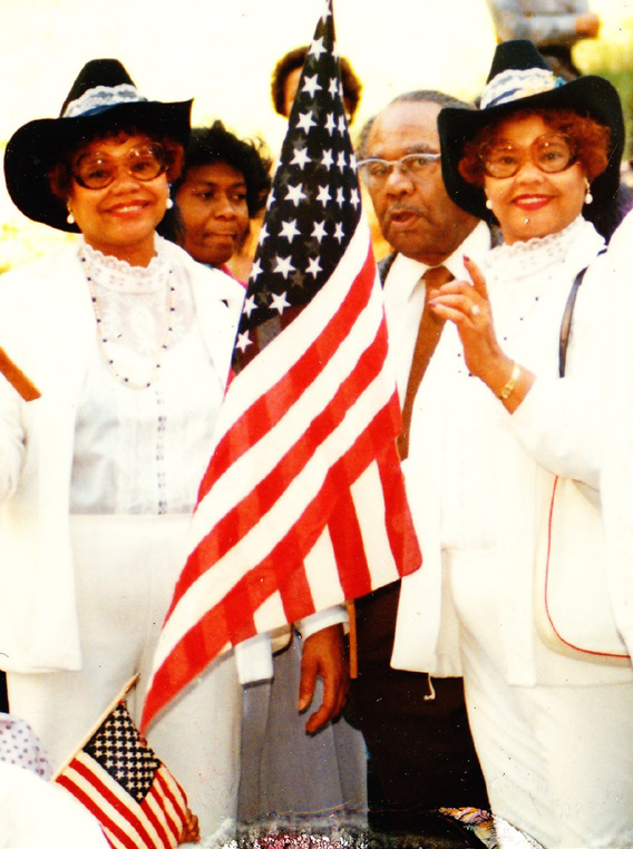 Twins standing in white with flags