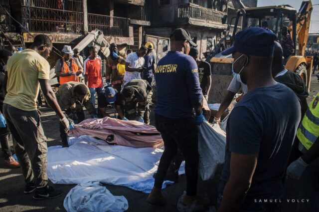 Rescuers wrapping dead bodies