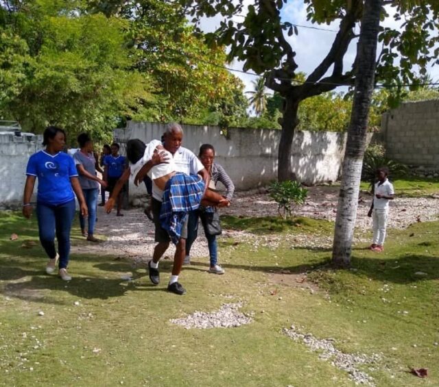 Employees of the nonprofit Capracare transport a person injured in a Dec. 21 earthquake that struck southwestern Haiti.