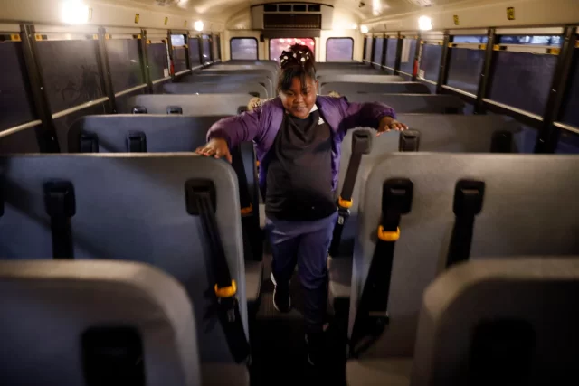 First grade helper Kensley Kennedy inspects the bus