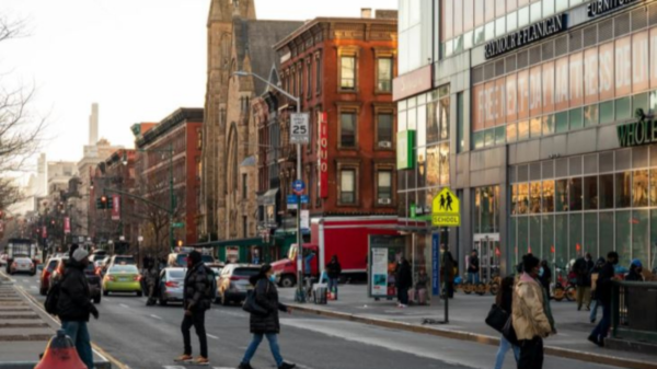 Pedestrians cross 125th Street in Harlem