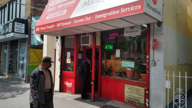 A man waits in the doorway of a Church Avenue money transfer store