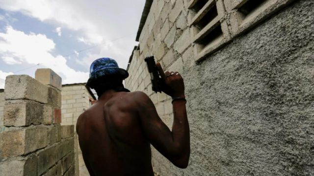 A gang member patrols in Cité Soleil slum