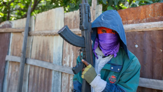 an armed gang member pose