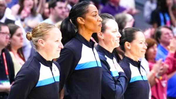 An all-women officiating crew stands