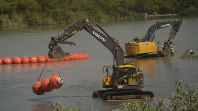 Workers deploy large buoys