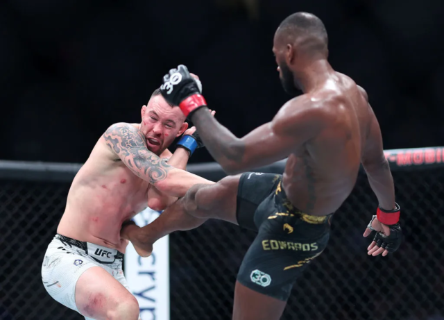 (R-L) Leon Edwards of Great Britain kicks Colby Covington