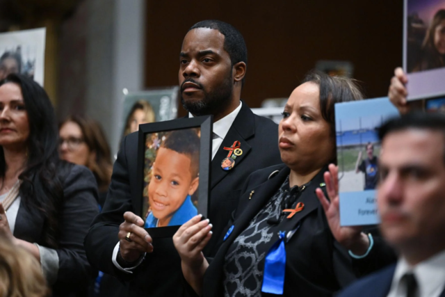 Family members hold up photos