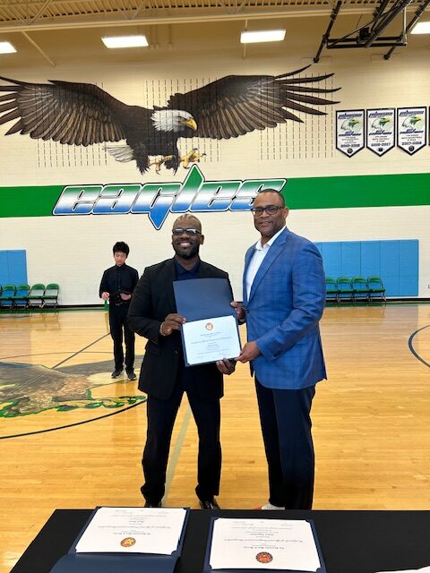 Congressman Marc Veasey presents a certifcate of honor to Johnson Middle School computer and technology teacher Patrick Yates