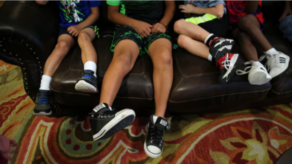boys sit on the couch at a licensed,