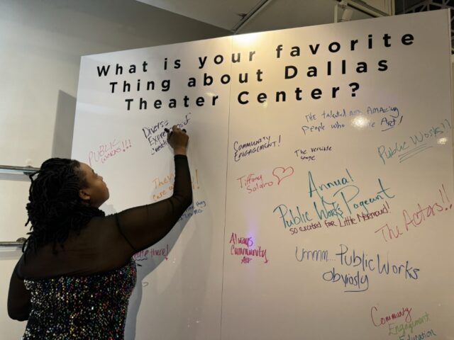 Attendee writes on message wall in exhibit room at Dallas Theater Center Centerstage 40 gala at the Fashion Industry Gallery in Dallas