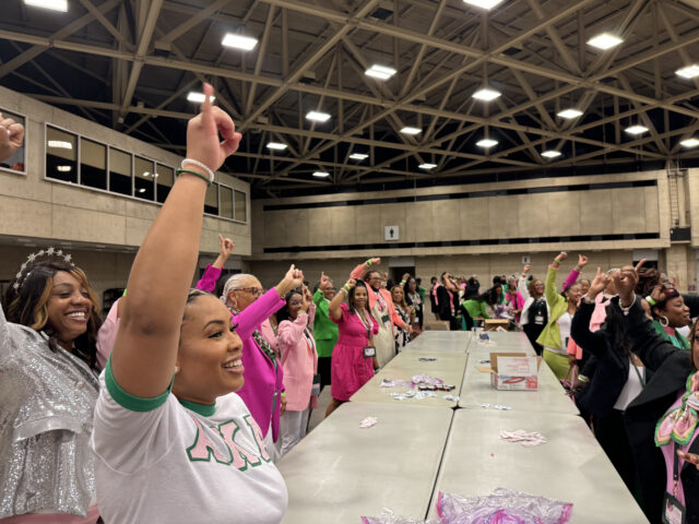 Sorority sisters hold pinkies in the air at conclusion of kit assembly