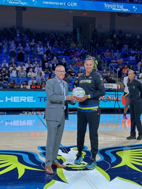 Dallas Wings GM Greg Bibb presents Satou Sabally with a game ball from the Paris Olympics where she played for her hometown Team Germany.