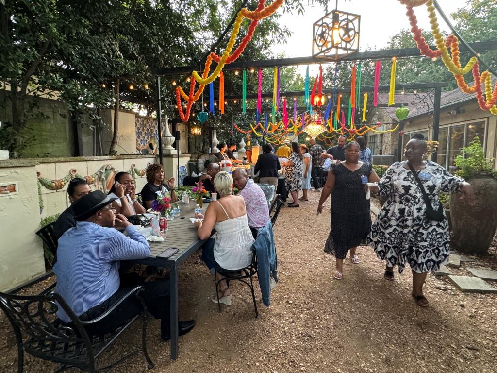 Attendees enjoying outdoors during HCDFW Rosie Casals Lifetime Achievement Celebration at residence in Dallas