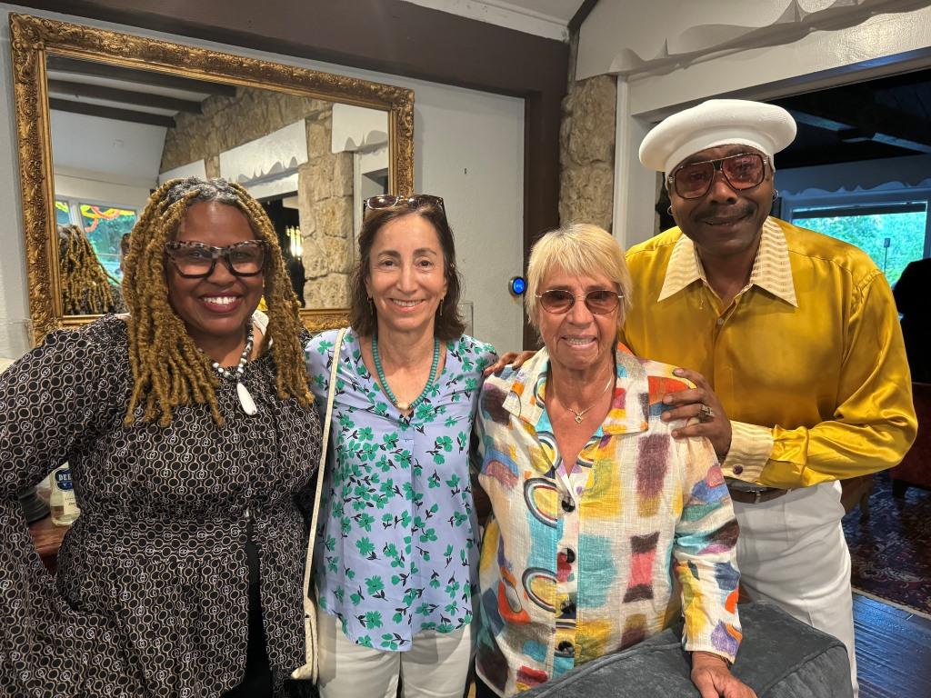 Attendees surround Rosie Casals (wearing multicolored shirt) during HCDFW Rosie Casals Lifetime Achievement Celebration at residence in Dallas